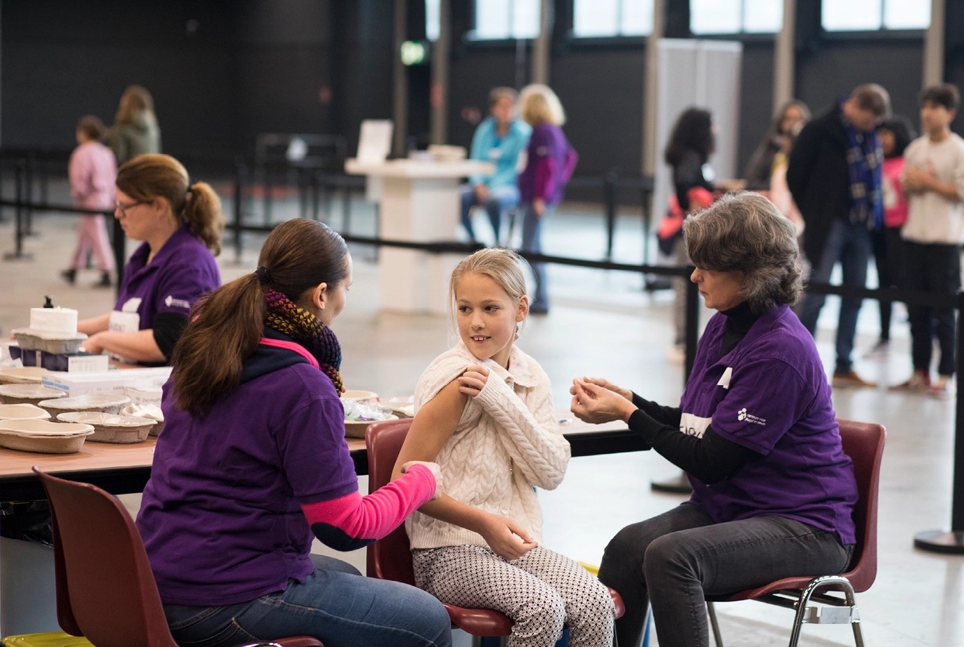 Meisje die haar prik haalt tijdens een vaccinatiedag