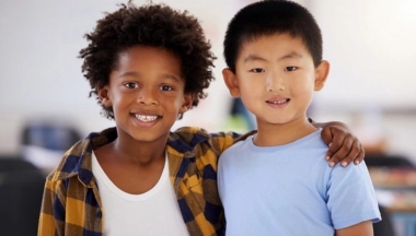 Jongetje die zijn arm over een ander jongetje heeft geslagen